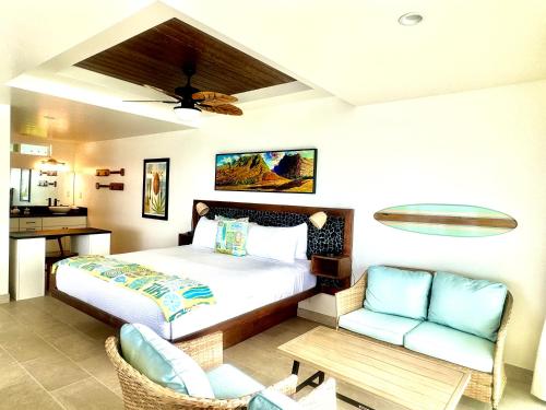 a bedroom with a bed and a chair and a table at Kona Tiki Hotel - No Resort Fees in Kailua-Kona