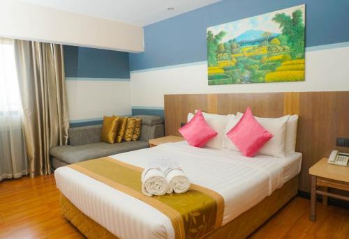 1 dormitorio con 1 cama con 2 toallas en Kemena Plaza Hotel, en Bintulu
