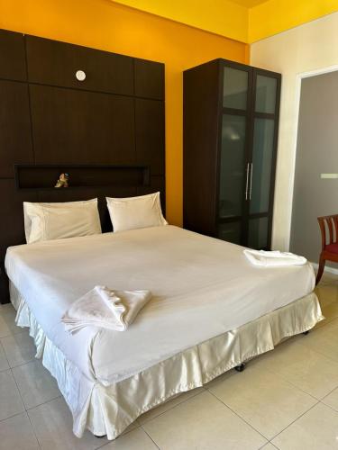 ein großes Bett mit weißer Bettwäsche und Kissen darauf in der Unterkunft Cozy Place in Patong Beach