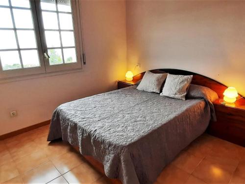 a bedroom with a bed with two pillows and two windows at Casa rural Llançà, 2 dormitorios, 4 personas - ES-170-21 in Llança
