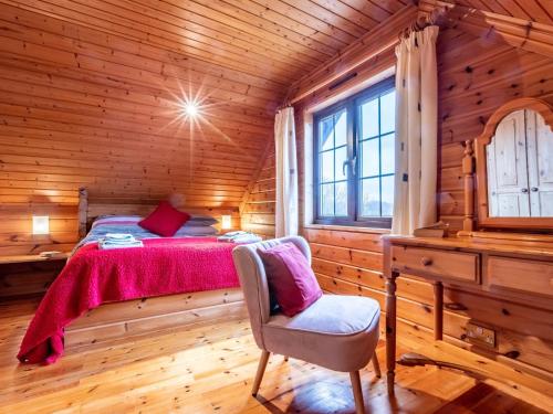 a bedroom with a bed in a wooden cabin at 3 Bed in Clovelly 00368 in Clovelly