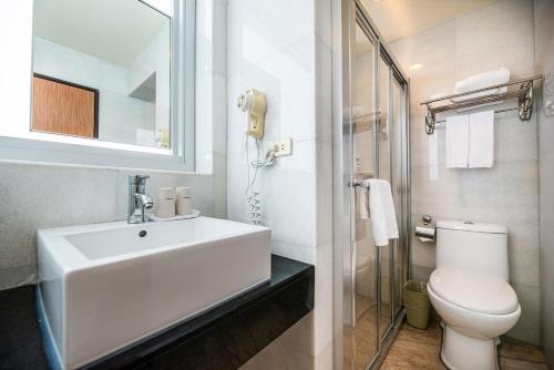 a white bathroom with a sink and a toilet at 沐棧行旅-花蓮Muchan Hotel-Hualien in Jian