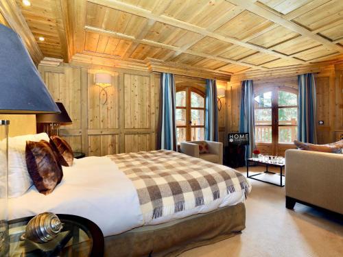 a bedroom with a large bed in a room with wooden walls at Chalet Courchevel 1850, 5 pièces, 8 personnes - FR-1-575-218 in Courchevel