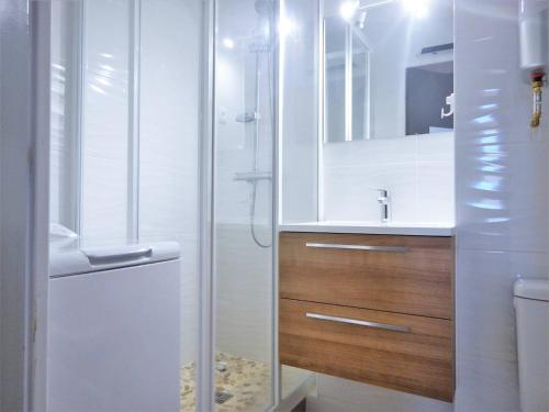 une salle de bain blanche avec une douche et un lavabo dans l'établissement Appartement 2 pièces avec loggia, garage, 3 min de la mer, classé 2 étoiles, ménage inclus - FR-1-251-552, à Bormes-les-Mimosas