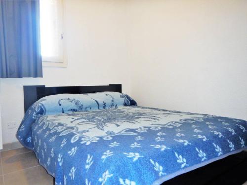 une chambre avec un lit avec une couette bleue dans l'établissement Appartement 2 pièces avec loggia, garage, 3 min de la mer, classé 2 étoiles, ménage inclus - FR-1-251-552, à Bormes-les-Mimosas