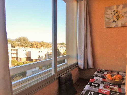 Cette chambre dispose d'une fenêtre et d'un bol de fruits sur une table. dans l'établissement Appartement 2 pièces avec loggia, garage, 3 min de la mer, classé 2 étoiles, ménage inclus - FR-1-251-552, à Bormes-les-Mimosas