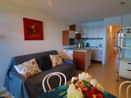 un salon avec un canapé et une cuisine dans l'établissement Charmant 2 pièces avec terrasse au bord de mer, Sète - FR-1-472A-298, à Sète