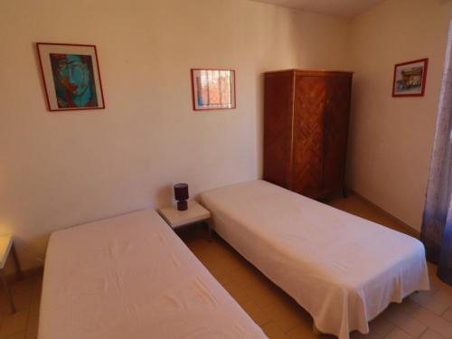 Cette chambre comprend 2 lits et une armoire. dans l'établissement Charmant 2 pièces avec terrasse au bord de mer, Sète - FR-1-472A-298, à Sète
