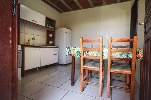 - une cuisine avec deux chaises en bois et une table dans l'établissement Pousada Salinas Valle, à Tramandaí