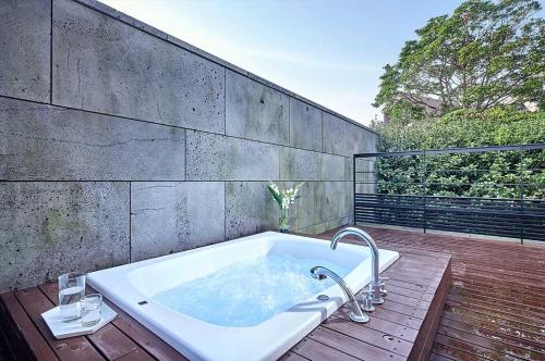 une baignoire installée au-dessus d'une terrasse en bois dans l'établissement Lotte Resort Jeju Artvillas, à Seogwipo