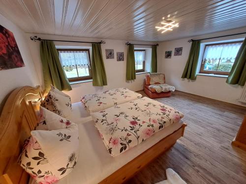 ein Schlafzimmer mit einem Bett und einem Stuhl in einem Zimmer in der Unterkunft Ferienwohnungen Kilianmühle in Berchtesgaden