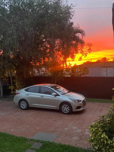 een auto geparkeerd op een oprit met een zonsondergang op de achtergrond bij Franzolo in Miami