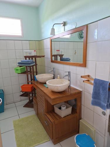 a bathroom with two sinks and a mirror at Villa bois rose in Petit-Bourg