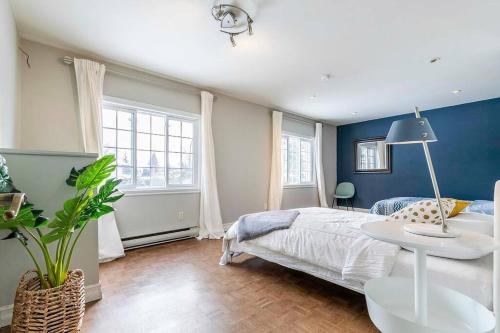 a bedroom with a bed and a blue wall at Fancy 4BDR near DT free parking in Brossard