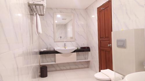 biała łazienka z umywalką i toaletą w obiekcie Puri Lovina w mieście Lovina