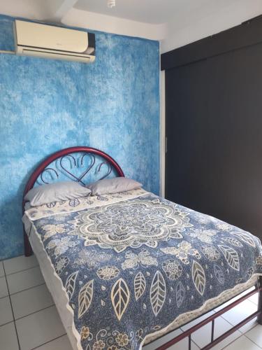 a bedroom with a bed with a blue wall at Casa cerca de ex hacienda temixco in Morelos