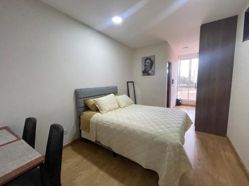 um quarto com uma cama e uma mesa em Monoambiente full amoblado Cala Cala piso 2 em Cochabamba