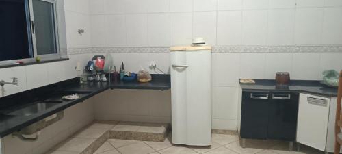 una pequeña cocina con nevera y fregadero en Hostel Kinu, en Belo Horizonte