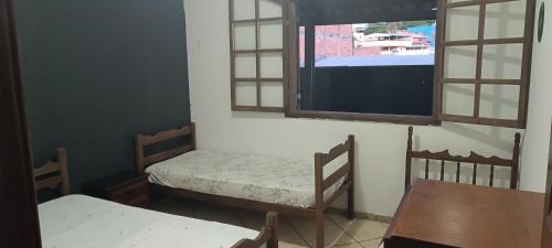 Habitación pequeña con 2 camas y ventana en Hostel Kinu, en Belo Horizonte