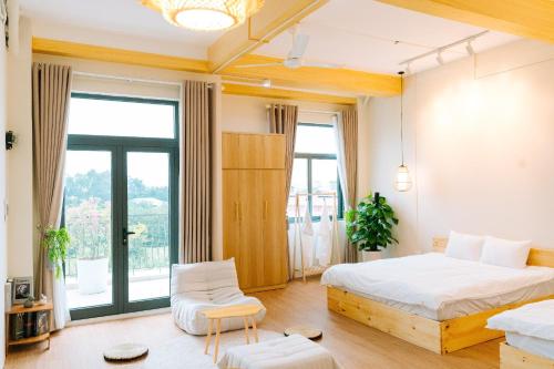 a bedroom with two beds and a large window at X-Stay in Hai Phong