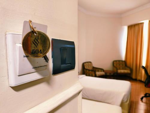 a hotel room with a clock on the wall at Presidency Kochi City Centre in Cochin