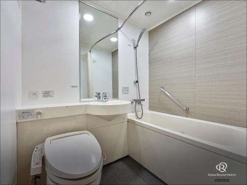 a bathroom with a toilet and a sink and a tub at Daiwa Roynet Hotel Sendai in Sendai