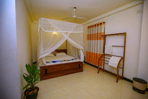 a bedroom with a bed with a mosquito net at Bakini Villa - Ahangama in Ahangama