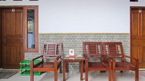 two chairs and a table and a table and two chairs at Hotel GRAND NEW SIJAGO in Wanasari