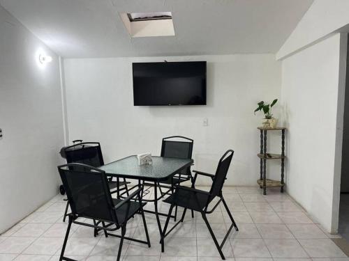 a dining room with a table and chairs and a television at Hermoso departamento con Patio in Apizaco
