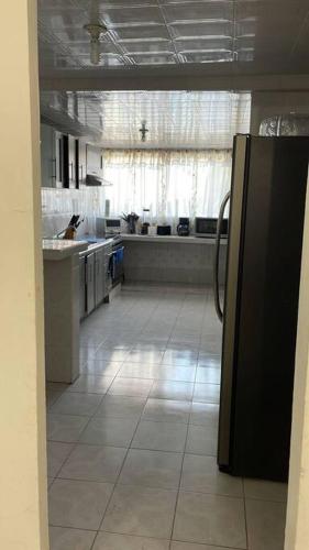 a kitchen with a refrigerator and a large window at Hermoso departamento con Patio in Apizaco
