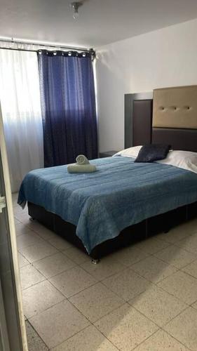 a bedroom with a large bed with a blue blanket at Hermoso departamento con Patio in Apizaco