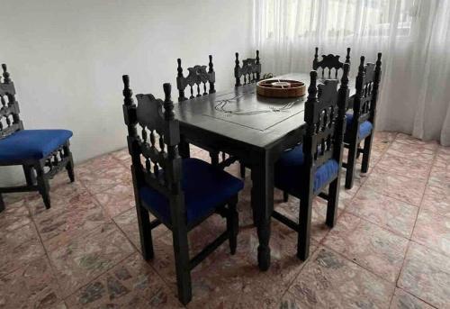 a dining room table with blue chairs and a black table at Hermoso departamento con Patio in Apizaco