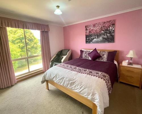 een slaapkamer met een paars bed en een raam bij Oscars Retreat in Kingston