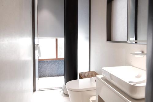 een badkamer met een toilet, een wastafel en een raam bij Glaze Garden Hotel in Yangzhou