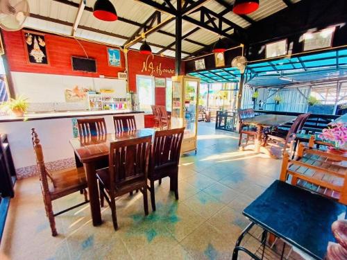 ein Restaurant mit Holztischen und -stühlen und einer Bar in der Unterkunft โรงแรมเอ็น.เจ. ธาตุพนม 