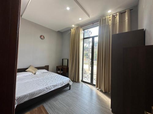 a bedroom with a bed and a large window at Vũ Homestay in Cao Bằng