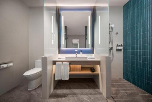 uma casa de banho com um lavatório, um WC e um espelho. em Holiday Inn Express Shenzhen Futian Center, an IHG Hotel em Shenzhen