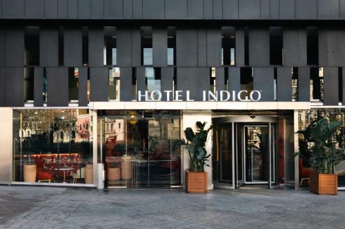 einen Laden vor einem hilton indico-Gebäude in der Unterkunft Hotel Indigo Barcelona Plaza Espana, an IHG Hotel in Barcelona