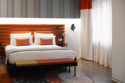 a bedroom with a large bed with a wooden headboard at Hotel Indigo Barcelona Plaza Espana by IHG in Barcelona