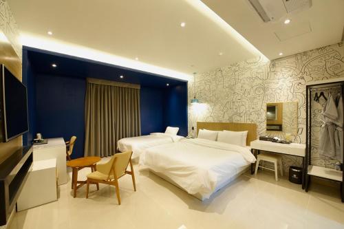 Hotel B في غوانغجو: غرفة فندقية بسريرين ومكتب وسرير