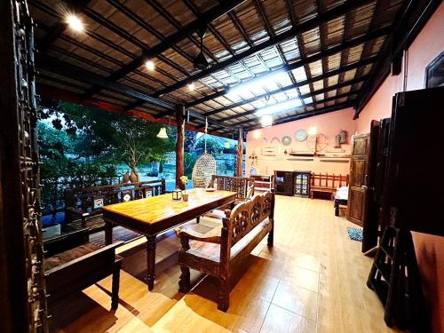 a large dining room with a table and chairs at บ้านมาดามกรีน Baan Madamn Green Nan in Nan