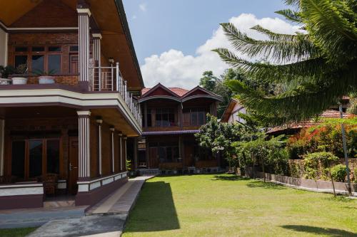 a house with a grass yard in front of it at Gokhon Guest House in Tuktuk Siadong