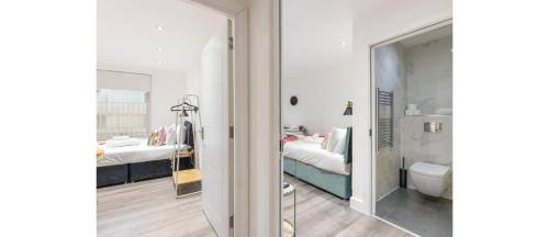 una camera con bagno dotato di letto e specchio di A Splash of Color: Spacious & Funky 3-BR Flat a Londra