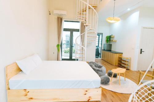 a bedroom with a bed and a spiral staircase at X-Stay in Hai Phong