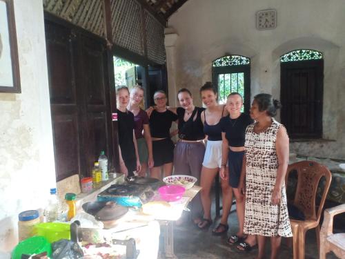 a group of people posing for a picture in a kitchen at White House in Unawatuna