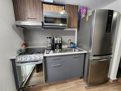 eine Küche mit einem Kühlschrank aus Edelstahl und einer Spüle in der Unterkunft Habitacion en Departamento Compartido in Mexiko-Stadt