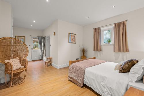 a bedroom with a bed and a wicker chair at Little Silver Nugget in High Bickington