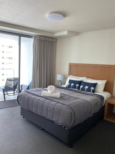 a bedroom with a large bed and a balcony at Cilento Mooloolaba in Mooloolaba