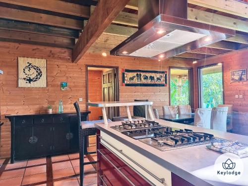 a kitchen with a stove and a counter top at Verger suspendu - avec piscine - 100m2 - Étang-Salé les Hauts in Gôl