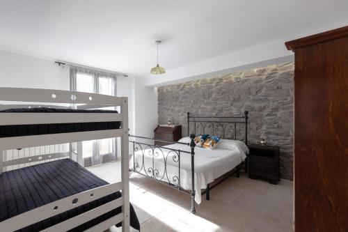 um quarto com 2 beliches e uma parede de pedra em Sunny House Bilo with Pool - Happy Rentals em Sanarica